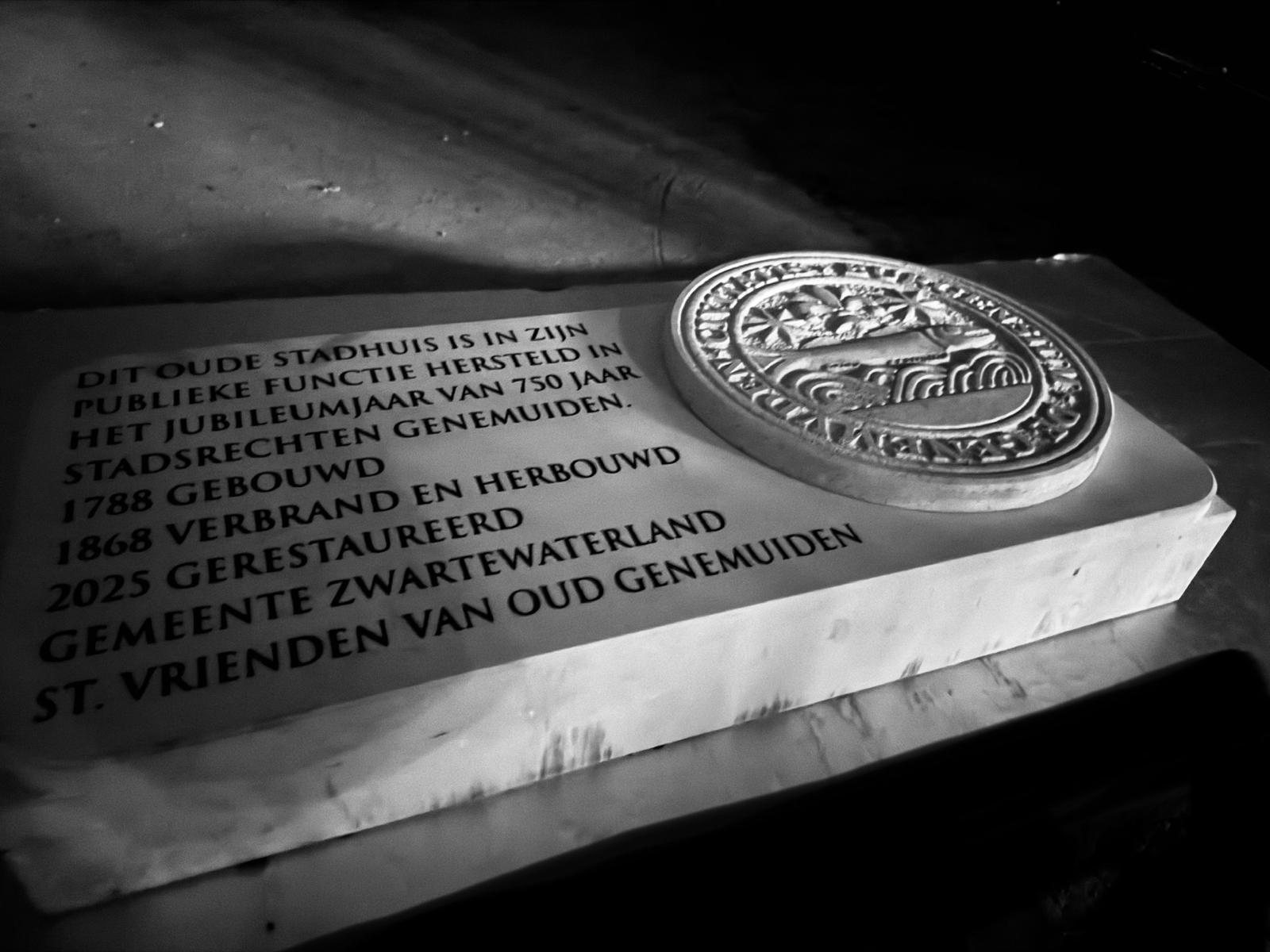 Detail van heraldiek en tekst in steen