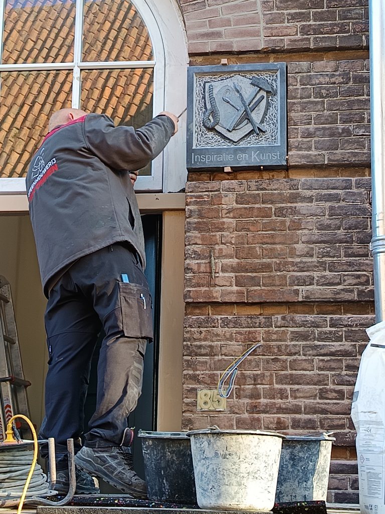 Werk aan een gevel tijdens restauratie van een historische steen